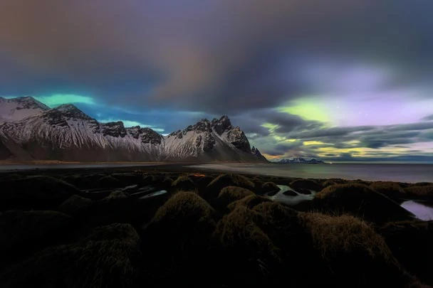 Les montagnes sous les aurores boréales à Höfn en Islande