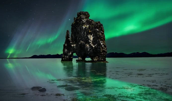 Le rocher basaltique de Hvitserkur en Islande sous les aurores boréales