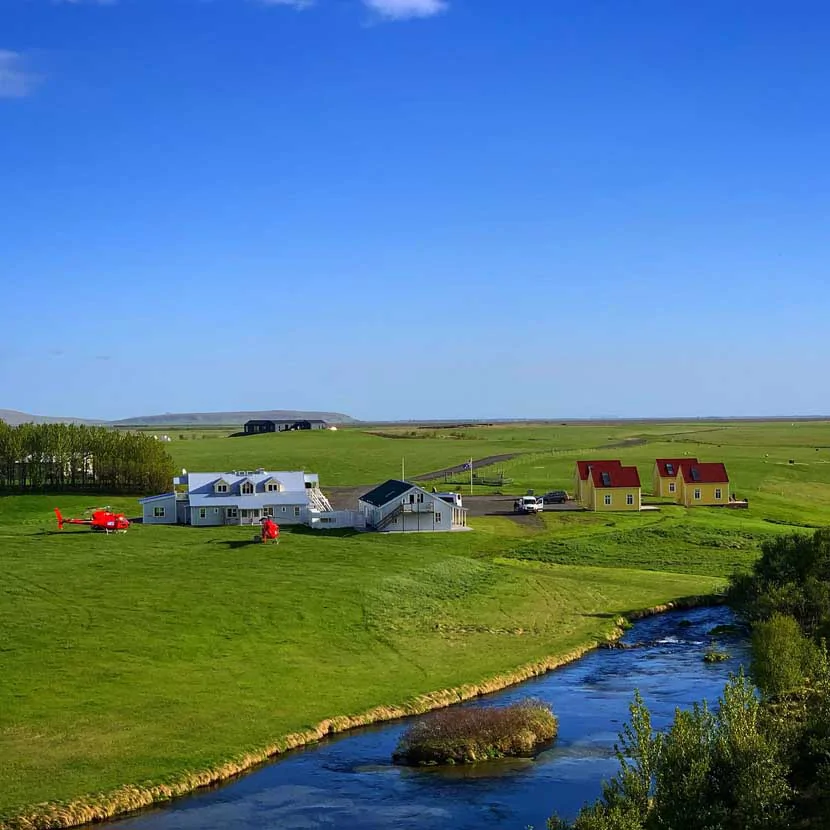 Le bâtiment principal, les cottages et la rivière de l'hôtel Laekur en Islande